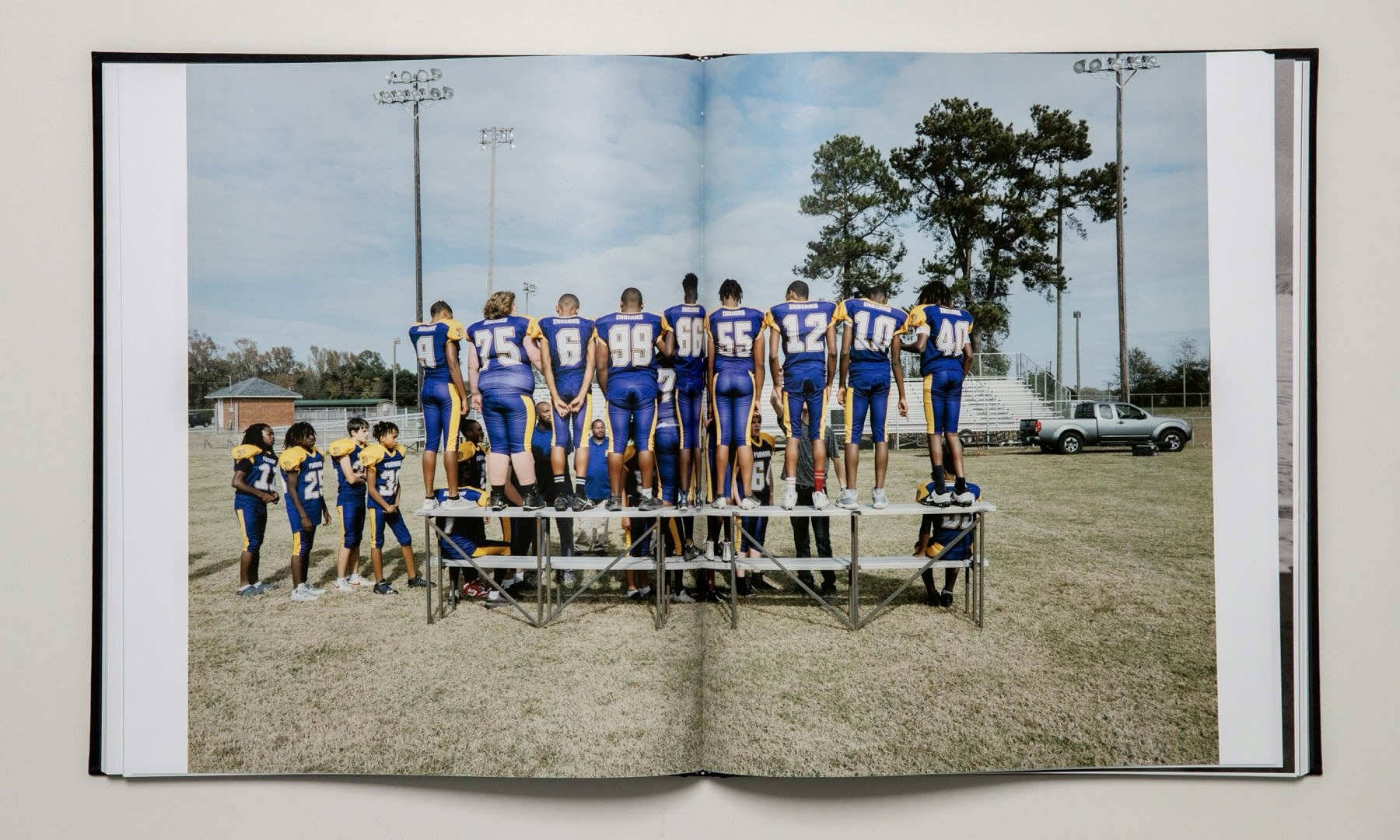 Open spread: a youth football team standing on bleachers in a field, seen from behind