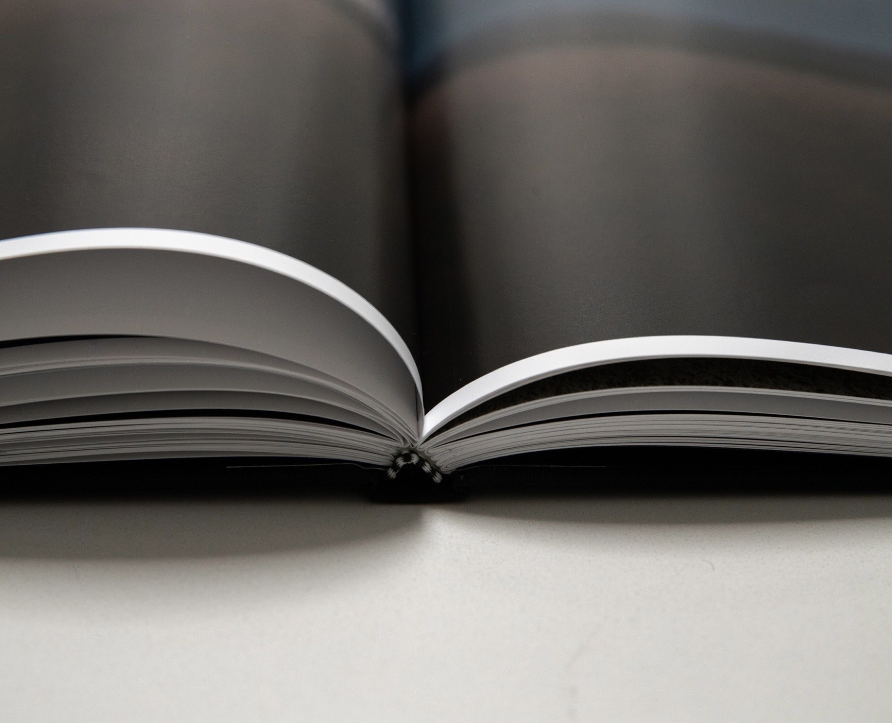 A close view of the book's sewn binding and page edges